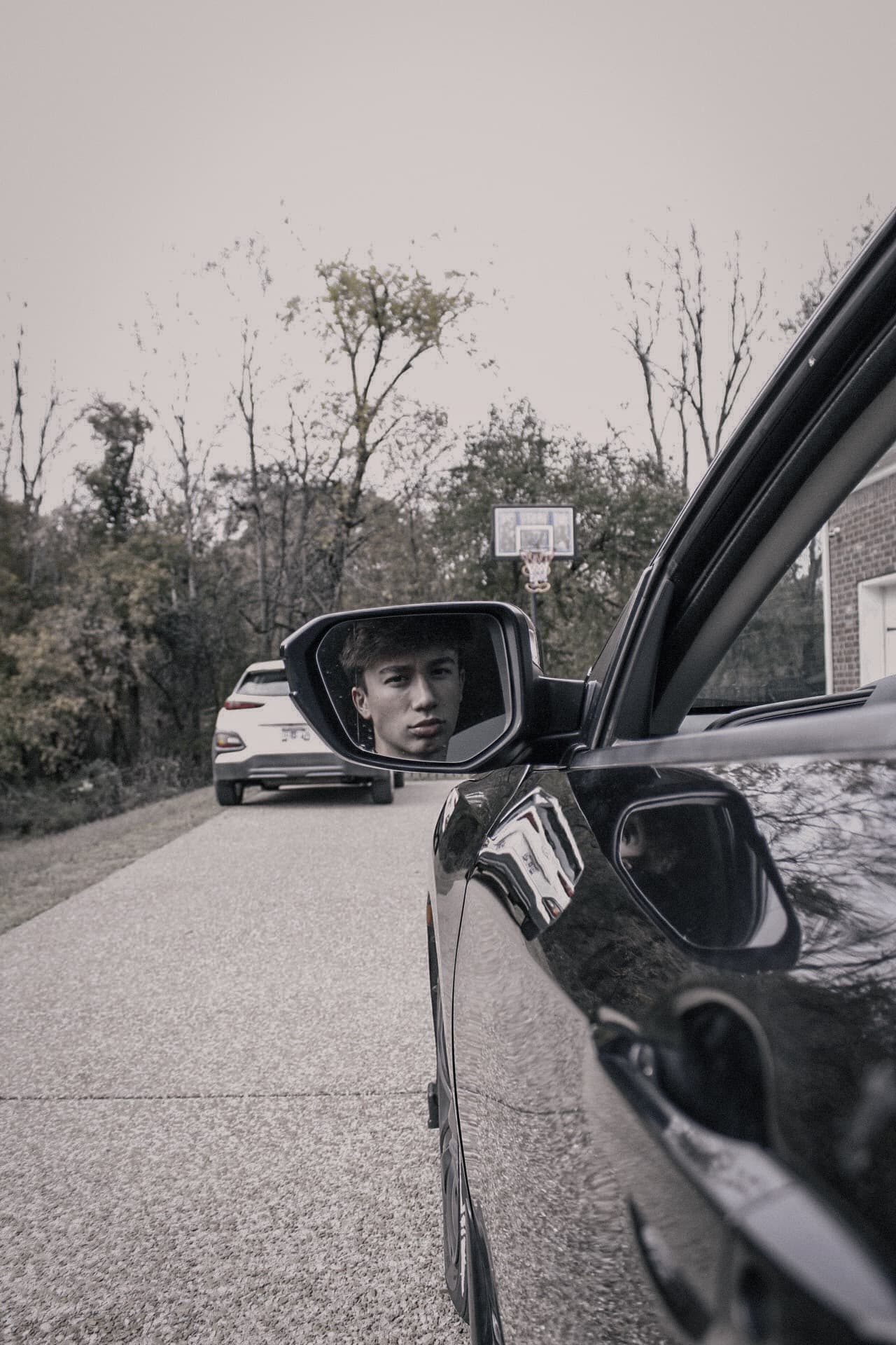 Side mirror reflection showing driver